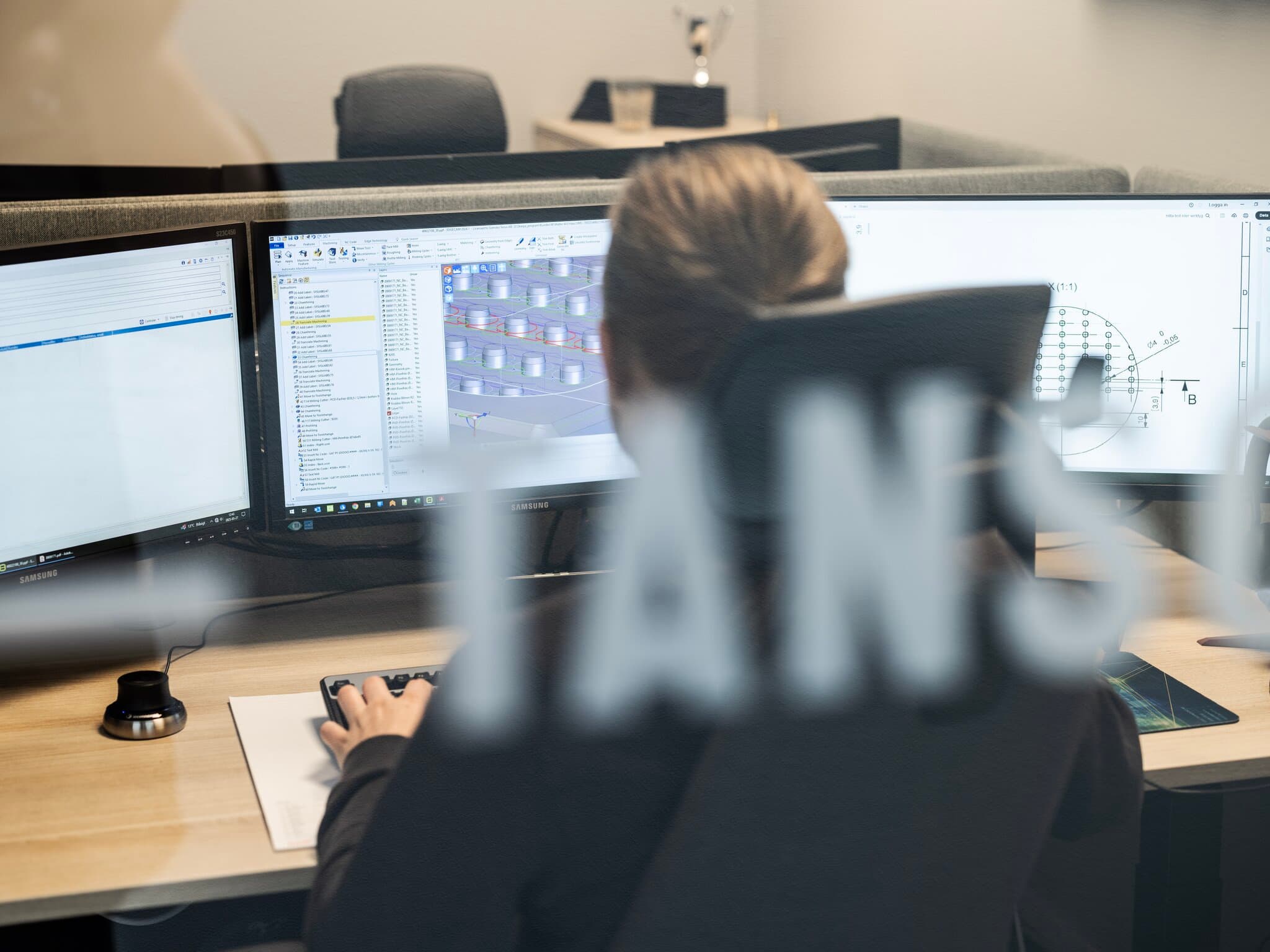 Bild tagen bakifrån på person som arbetar med CAD/CAM