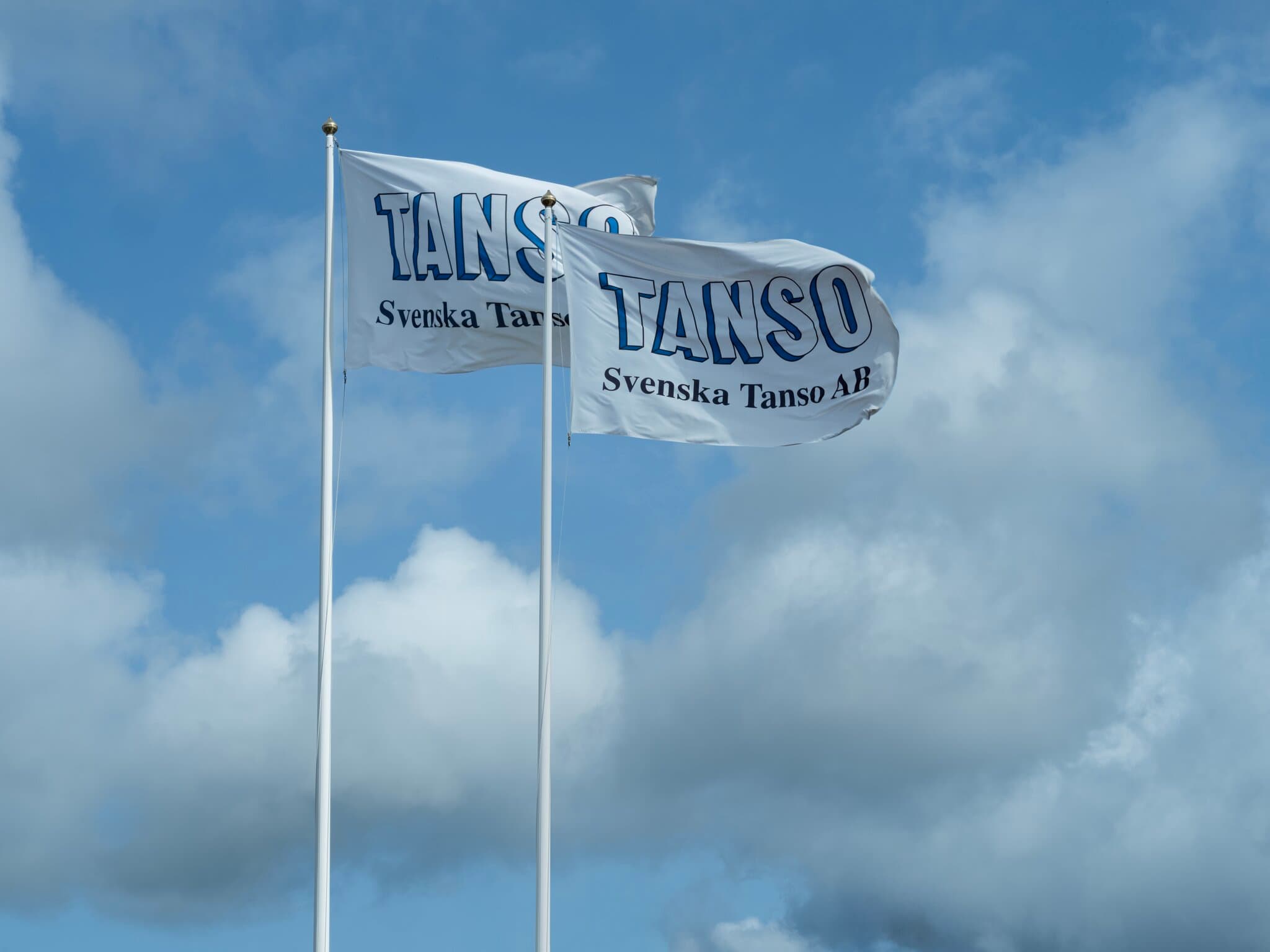Flaggor med Svenska Tanso AB:s logotyp
