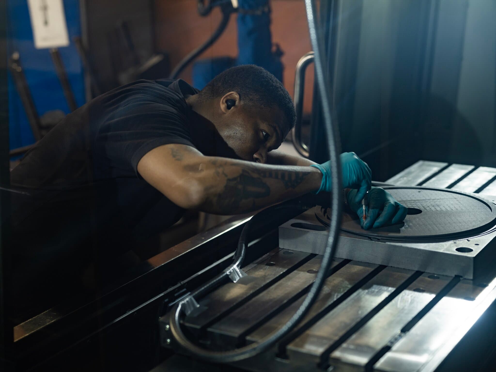 Person machining graphite component in workshop environment